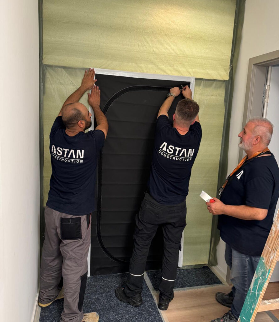Inhaber Dincer Astan mit zwei Mitarbeitern von Astan Construction bei Arbeiten in Berlin